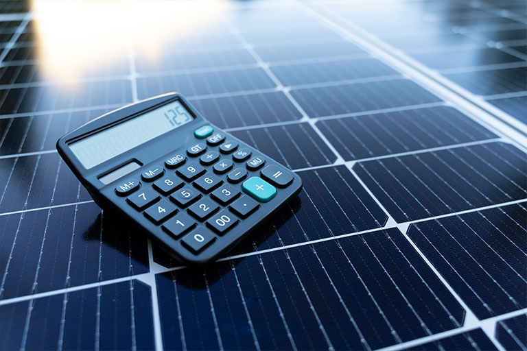 calculatrice posée sur un panneau solaire montrant la rentabilité