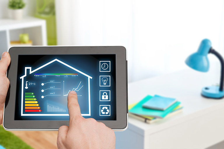 Une main ajuste les réglages de chauffage d'une maison sur une tablette numérique, affichant un écran de contrôle intelligent pour la gestion domestique, avec un bureau moderne flou en arrière-plan.